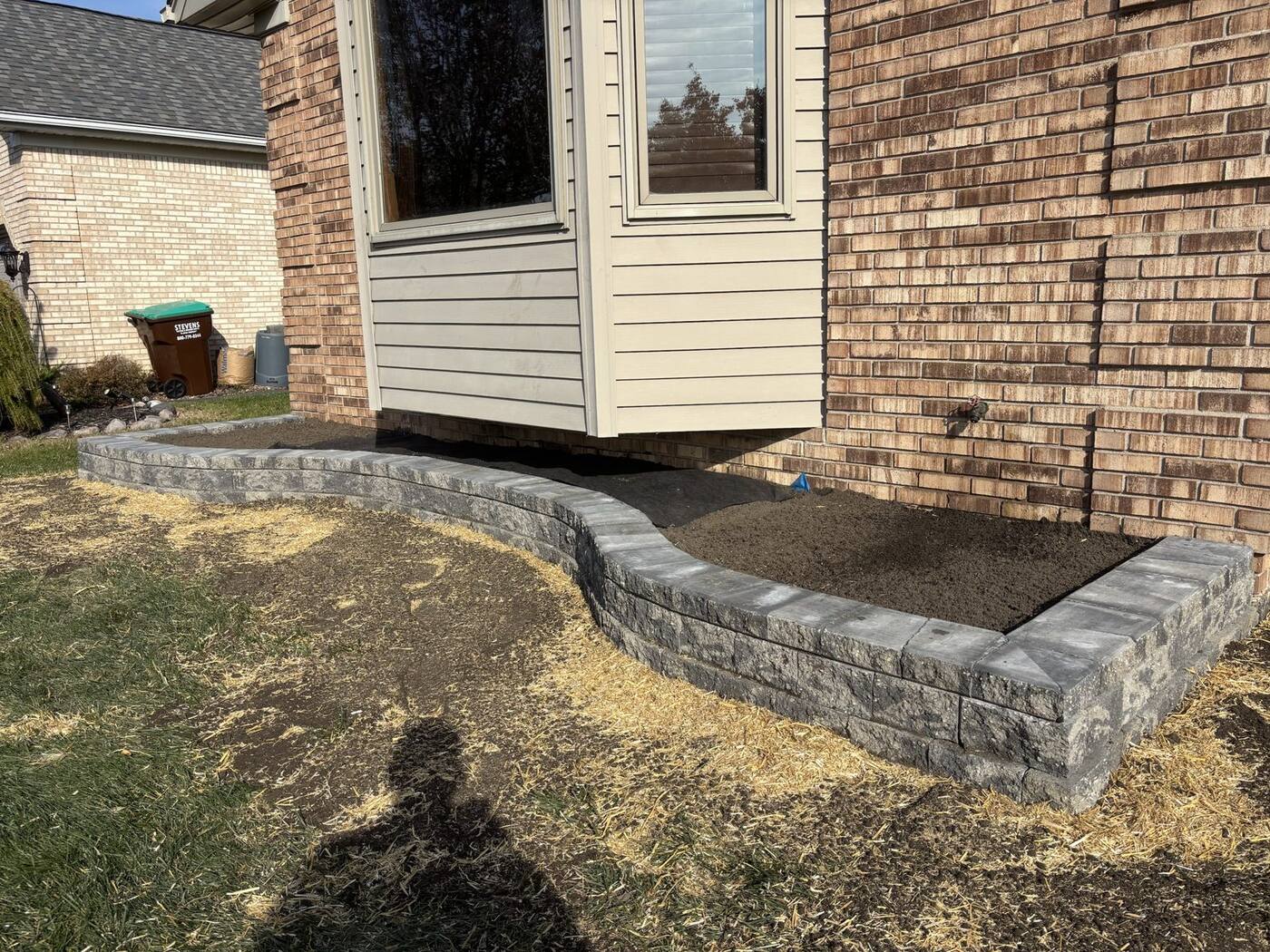 Curved garden wall under a bay window